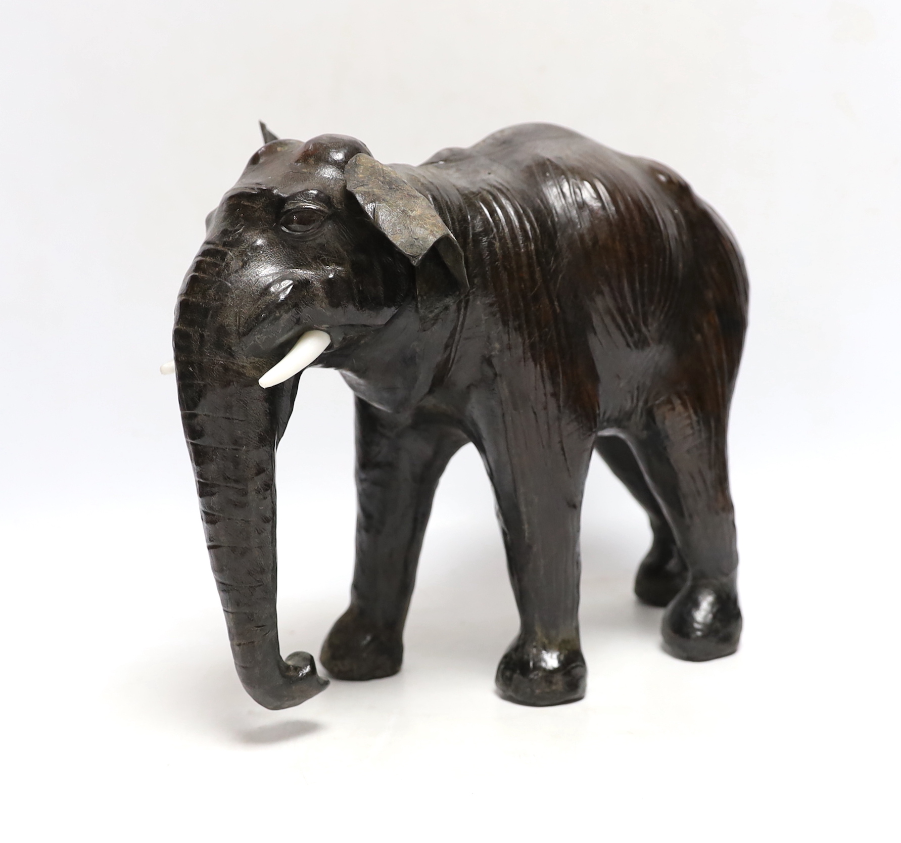 A leather elephant, stamped Liberty to the underside, 30cm wide